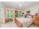 Cozy bedroom featuring a bed, desk, and windows offering a view of the surrounding trees and natural light at 2612 Scarlet Sage Ct, Raleigh, NC 27613