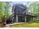 Back of a grey, two-story home with a screened porch and two decks in a lush forest setting at 2612 Scarlet Sage Ct, Raleigh, NC 27613