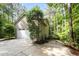 View of home's attached garage, well-manicured landscaping, and private, wooded lot at 2612 Scarlet Sage Ct, Raleigh, NC 27613