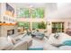 Bright and open living room featuring large windows, a stone fireplace, and comfortable seating at 2612 Scarlet Sage Ct, Raleigh, NC 27613