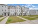 A row of townhomes showcase well-kept lawns and walkways, under a partly cloudy sky at 2708 Chert Ln, Raleigh, NC 27610