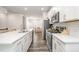 Modern kitchen featuring white cabinets, stainless steel appliances, and a long island with seating at 2708 Chert Ln, Raleigh, NC 27610