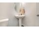 Stylish powder room featuring a pedestal sink, oval mirror, and neutral paint tones at 2708 Chert Ln, Raleigh, NC 27610