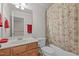 Bathroom with a single sink, toilet and shower-tub combination with a floral shower curtain at 276 Linden Park Ln, Cary, NC 27519