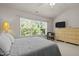 Bright bedroom featuring a large window, ceiling fan, neutral walls, and a cozy bed at 276 Linden Park Ln, Cary, NC 27519