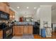 Well-equipped kitchen with wooden cabinets, black appliances, and a seamless connection to other living spaces at 276 Linden Park Ln, Cary, NC 27519
