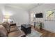 Cozy living room featuring a brown leather sofa, wood floors, and a TV on a stand at 276 Linden Park Ln, Cary, NC 27519