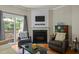 Living room features a fireplace with a TV, sliding glass doors to patio and comfortable armchairs at 276 Linden Park Ln, Cary, NC 27519