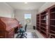 A home office with a wooden roll-top desk, rolling chair, and large bookshelf beside a sunlit window at 276 Linden Park Ln, Cary, NC 27519