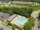 Community pool and spa with lounge chairs, tables, and umbrellas are surrounded by trees at 276 Linden Park Ln, Cary, NC 27519
