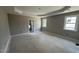 Spacious bedroom featuring tray ceiling detail, two windows, and rough-in electrical for ceiling fan at 2760 Rains Mill Rd, Princeton, NC 27569