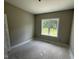 Cozy bedroom with neutral paint and a large window overlooking the yard with unfinished flooring at 2776 Rains Mill Rd, Princeton, NC 27569