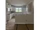 An incomplete kitchen with white cabinets, light gray walls and unfinished flooring covered with construction materials at 2776 Rains Mill Rd, Princeton, NC 27569