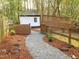 Inviting backyard featuring a stone pathway and a charming white outbuilding at 2907 University Dr, Durham, NC 27707
