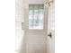Beautiful tiled shower features glass block window, shower niche, and updated fixtures at 2907 University Dr, Durham, NC 27707