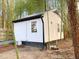 Charming white cottage with a metal roof nestled amongst lush bamboo trees at 2907 University Dr, Durham, NC 27707