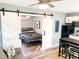 Living space with sliding barn door leading to bedroom and compact kitchen at 2907 University Dr, Durham, NC 27707