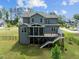 Lovely back elevation features a large wooden deck, screened porch, and lush green yard enclosed by a black fence at 3053 Roy Ct, Apex, NC 27523