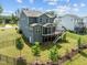 Beautiful back elevation with a large wooden deck, screened porch, and manicured lawn enclosed by a black fence at 3053 Roy Ct, Apex, NC 27523