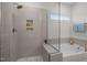 Modern bathroom featuring a glass-enclosed shower and soaking tub next to a window at 3053 Roy Ct, Apex, NC 27523