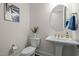 Stylish powder room featuring a pedestal sink, round mirror, and elegant decor at 3053 Roy Ct, Apex, NC 27523