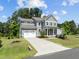Charming two-story home features a gray exterior, red door, well-manicured lawn, and attached two-car garage at 3053 Roy Ct, Apex, NC 27523