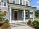 Covered front porch features white columns, stone steps, and a red front door, offering a welcoming entrance at 3053 Roy Ct, Apex, NC 27523