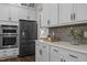 Close-up of the kitchen featuring white cabinets, stainless steel appliances, and subway tile backsplash at 3053 Roy Ct, Apex, NC 27523