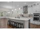 Bright kitchen boasts white cabinets, quartz countertops, stainless steel appliances, and an island with seating at 3053 Roy Ct, Apex, NC 27523