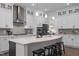 Bright kitchen boasts white cabinets, quartz countertops, stainless steel appliances, and an island with seating at 3053 Roy Ct, Apex, NC 27523