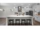 Bright kitchen boasts white cabinets, quartz countertops, stainless steel appliances, and an island with seating at 3053 Roy Ct, Apex, NC 27523