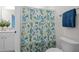 Shower with botanical curtain and white tile, next to the toilet and towel rack at 3053 Roy Ct, Apex, NC 27523