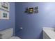 Stylish powder room features blue walls, decorative artwork and a sink with storage at 308 Trappers Sack Rd, Cary, NC 27513