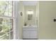 Bathroom with a well-lit vanity, featuring a marble countertop, white cabinets, and a large window showcasing a view at 308 Trappers Sack Rd, Cary, NC 27513