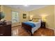 Bedroom with hardwood floors, a bed, and side tables, illuminated by lamps, offering a cozy and inviting atmosphere at 308 Trappers Sack Rd, Cary, NC 27513