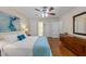 Bedroom with hardwood floors, a bed, and a dresser, illuminated by a ceiling fan and natural light at 308 Trappers Sack Rd, Cary, NC 27513