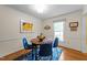 Cozy dining area featuring natural light, a wood table, and blue chairs on a decorative area rug at 308 Trappers Sack Rd, Cary, NC 27513