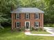 Charming brick home featuring black shutters, a well-manicured lawn, and mature trees offering natural shade at 308 Trappers Sack Rd, Cary, NC 27513
