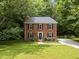 Beautiful two-story brick home with a manicured front lawn, black shutters and a tree-lined lot at 308 Trappers Sack Rd, Cary, NC 27513