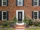 A close-up shot of a brick home's front door with black shutters and green landscaping at 308 Trappers Sack Rd, Cary, NC 27513