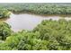 Scenic aerial view capturing a serene lake surrounded by lush greenery and mature trees at 308 Trappers Sack Rd, Cary, NC 27513