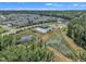 Aerial view of a residential community featuring houses, ponds, community pool, and green spaces at 3181 Zebroid Way, New Hill, NC 27562