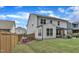 A grassy backyard is fenced and offers a patio for outdoor seating and play equipment for children at 3181 Zebroid Way, New Hill, NC 27562
