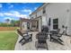 A backyard patio has black Adirondack chairs, a grill and a lovely pergola to keep the area shady at 3181 Zebroid Way, New Hill, NC 27562