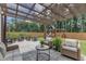 Relax on this backyard patio, with comfortable seating, an overhead shade and a playground in the yard at 3181 Zebroid Way, New Hill, NC 27562