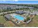 Aerial view of community pool, playground, clubhouse, and surrounding residential neighborhood at 3181 Zebroid Way, New Hill, NC 27562