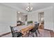 Bright dining room with a wooden table, chandelier, and elegant white wainscoting at 3181 Zebroid Way, New Hill, NC 27562