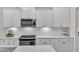 Close-up of kitchen featuring white cabinets, subway tile backsplash, stainless steel appliances, and quartz countertops at 3181 Zebroid Way, New Hill, NC 27562