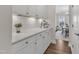 Bright kitchen area with white cabinets, stylish hardware, quartz countertops, and open view to dining area at 3181 Zebroid Way, New Hill, NC 27562