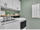 Practical laundry room with modern washer and dryer, white cabinets, and shelf at 3181 Zebroid Way, New Hill, NC 27562